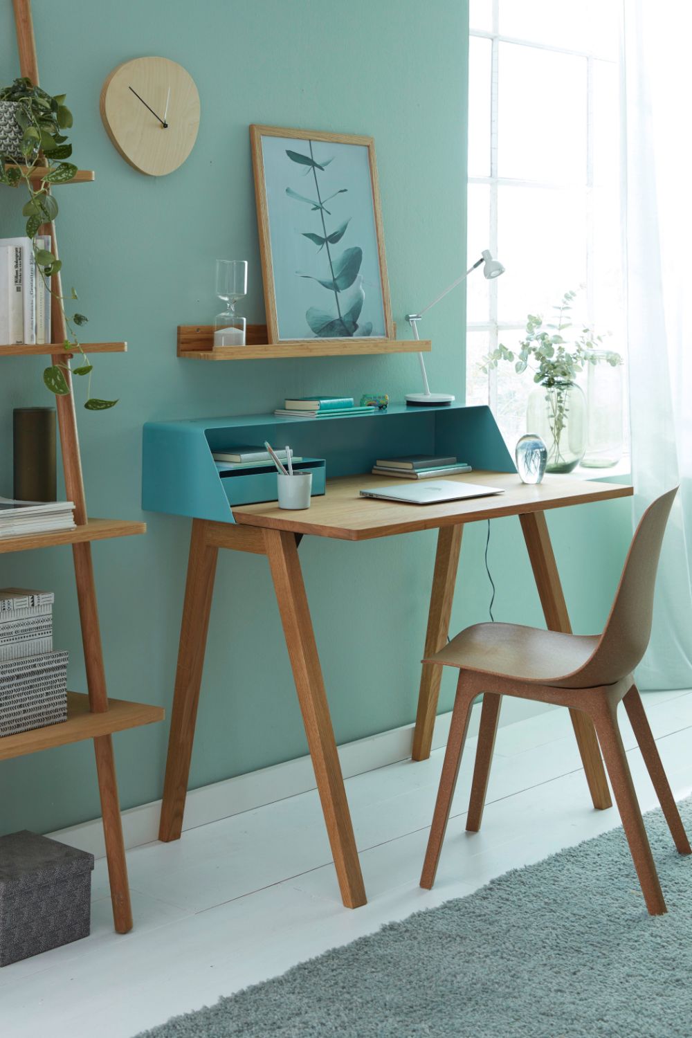 A productive home office with a desk and chair in a room with green walls.