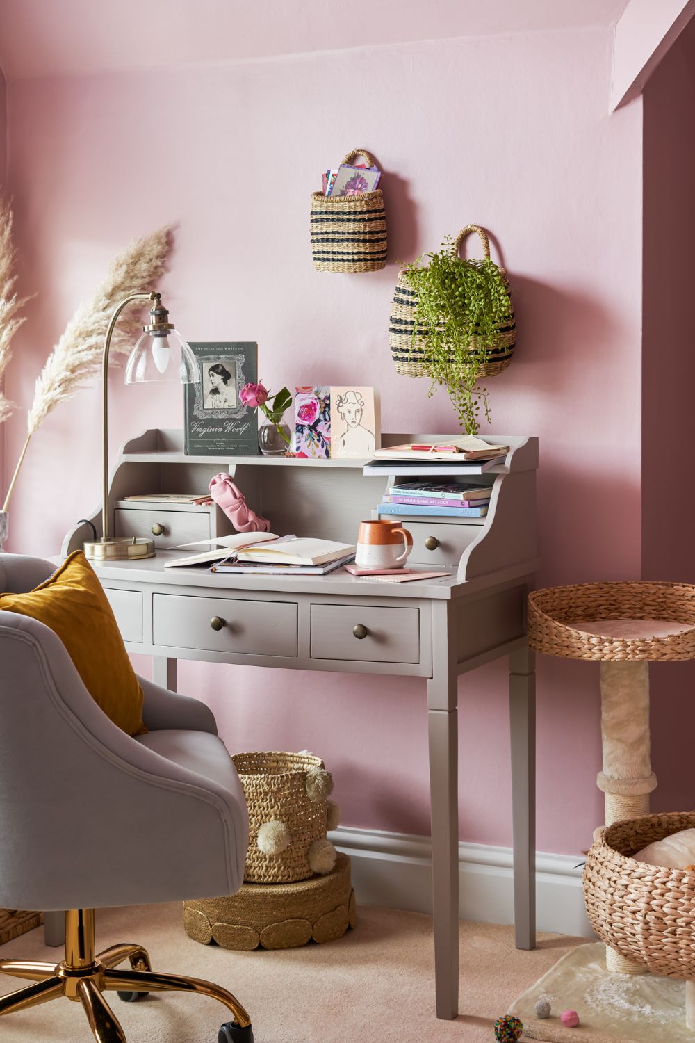 A productive home office with a pink and grey desk and chair.
