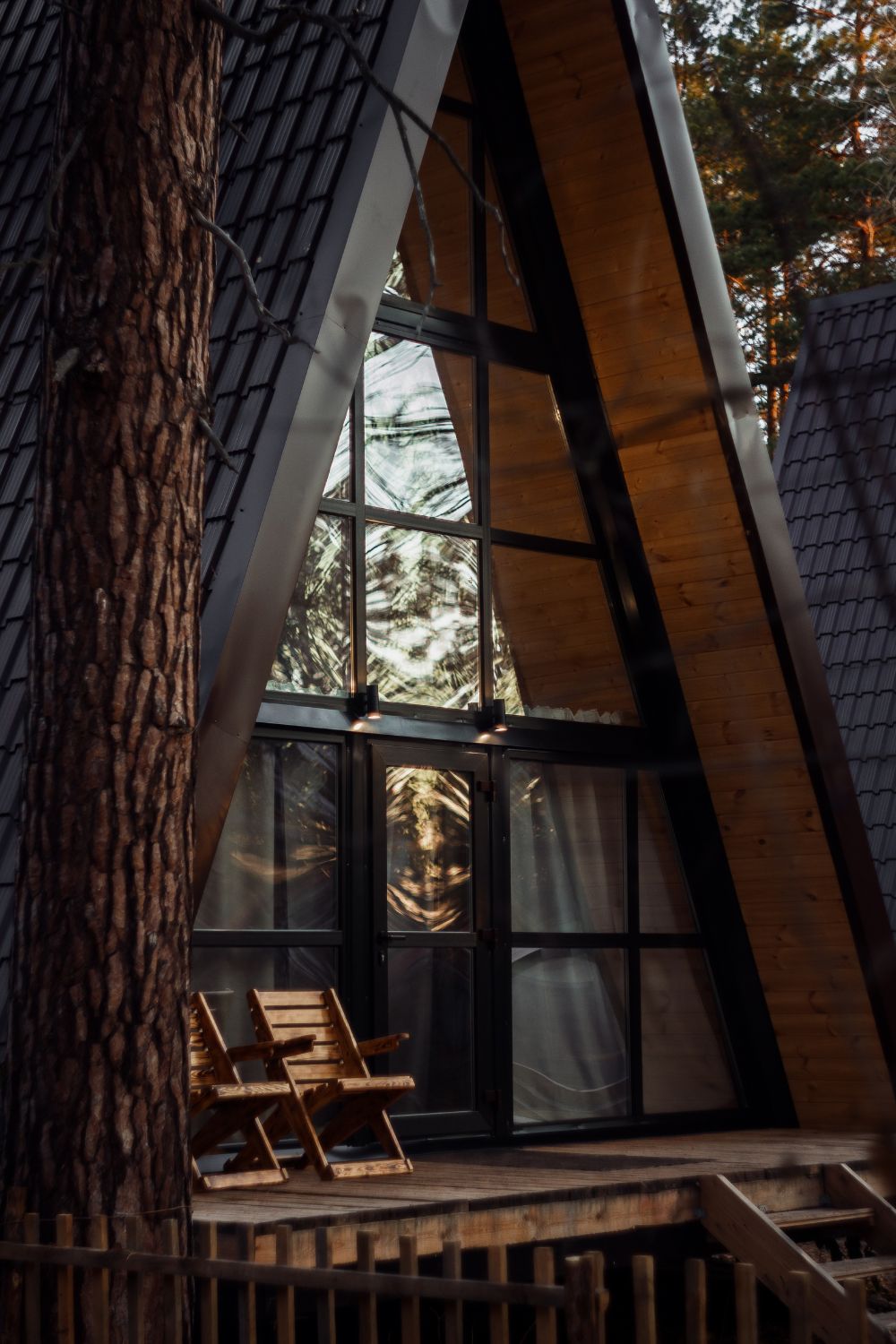 A luxurious wooden cabin nestled in the serene woods, complete with a spacious wooden deck for the perfect family getaway.