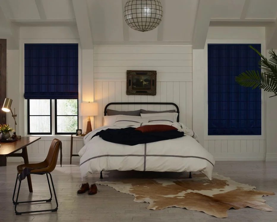 Enhance your home with a bedroom featuring custom blue blinds and a cowhide rug.