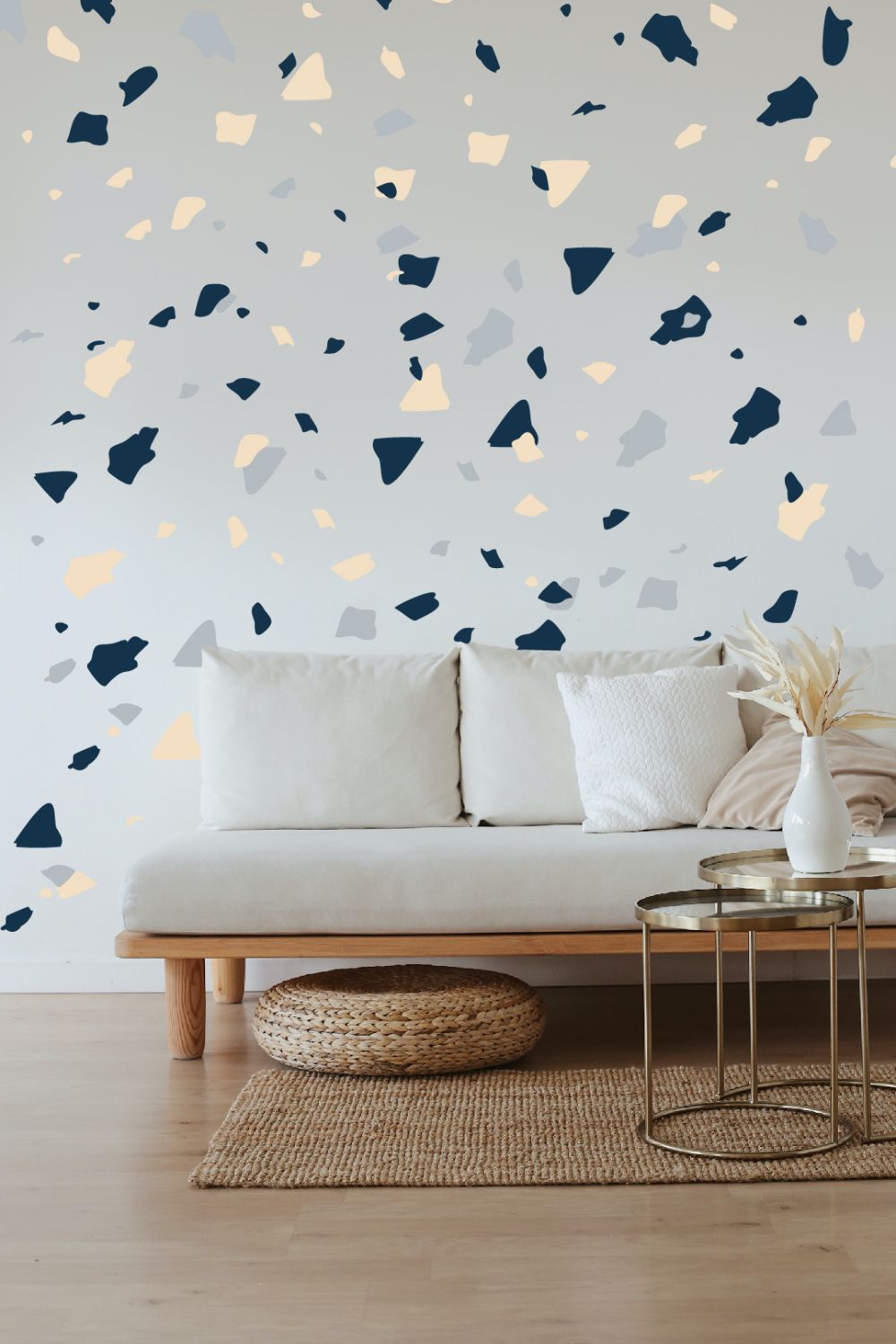 A living room with a white couch and blue and yellow confetti wall decals installed on laminate flooring.