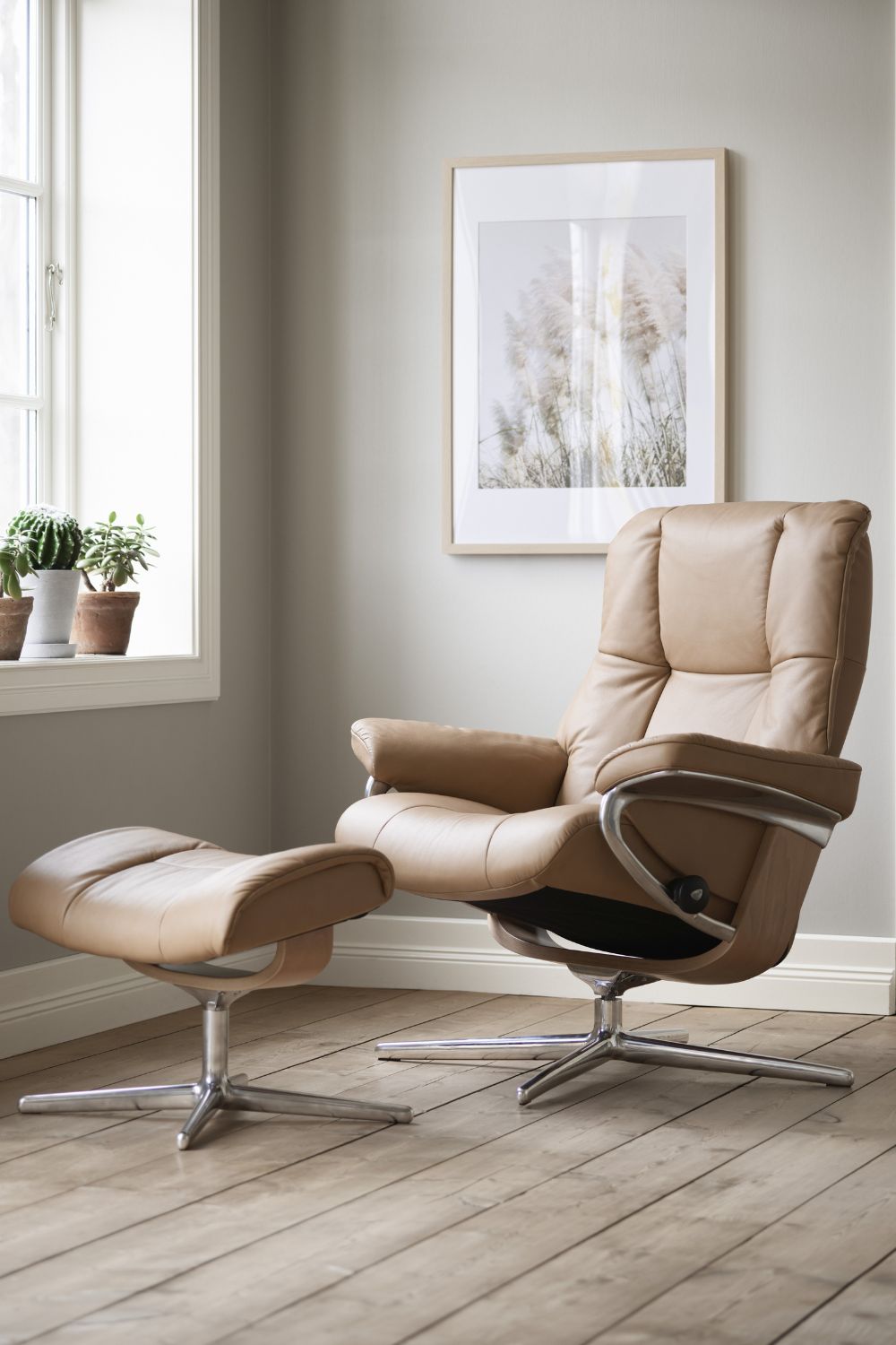 A PROFESSIONALLY installed tan leather recliner and ottoman in a room with laminate flooring.