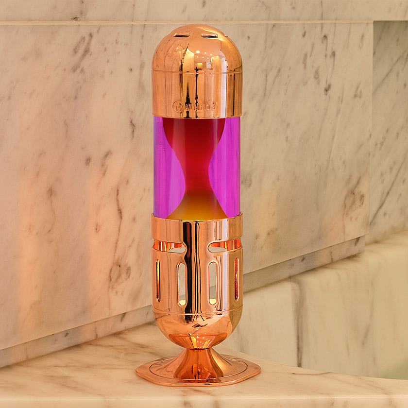 A copper hourglass sitting on top of a marble counter, worth £65.