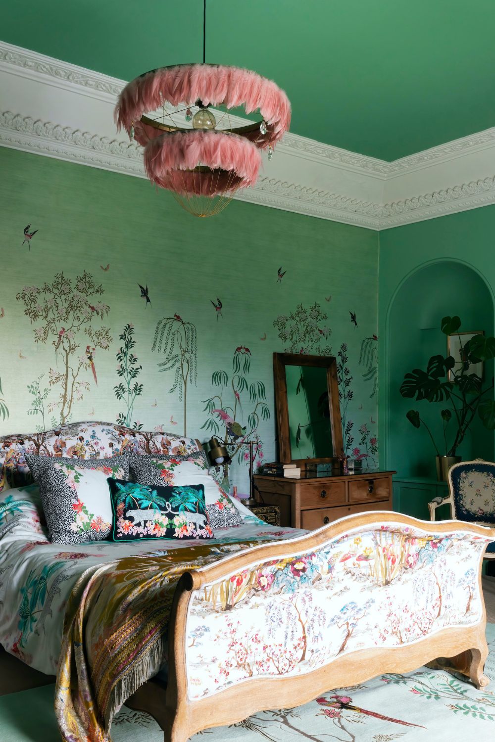 A upgraded bedroom with a bed surrounded by floral wallpaper.