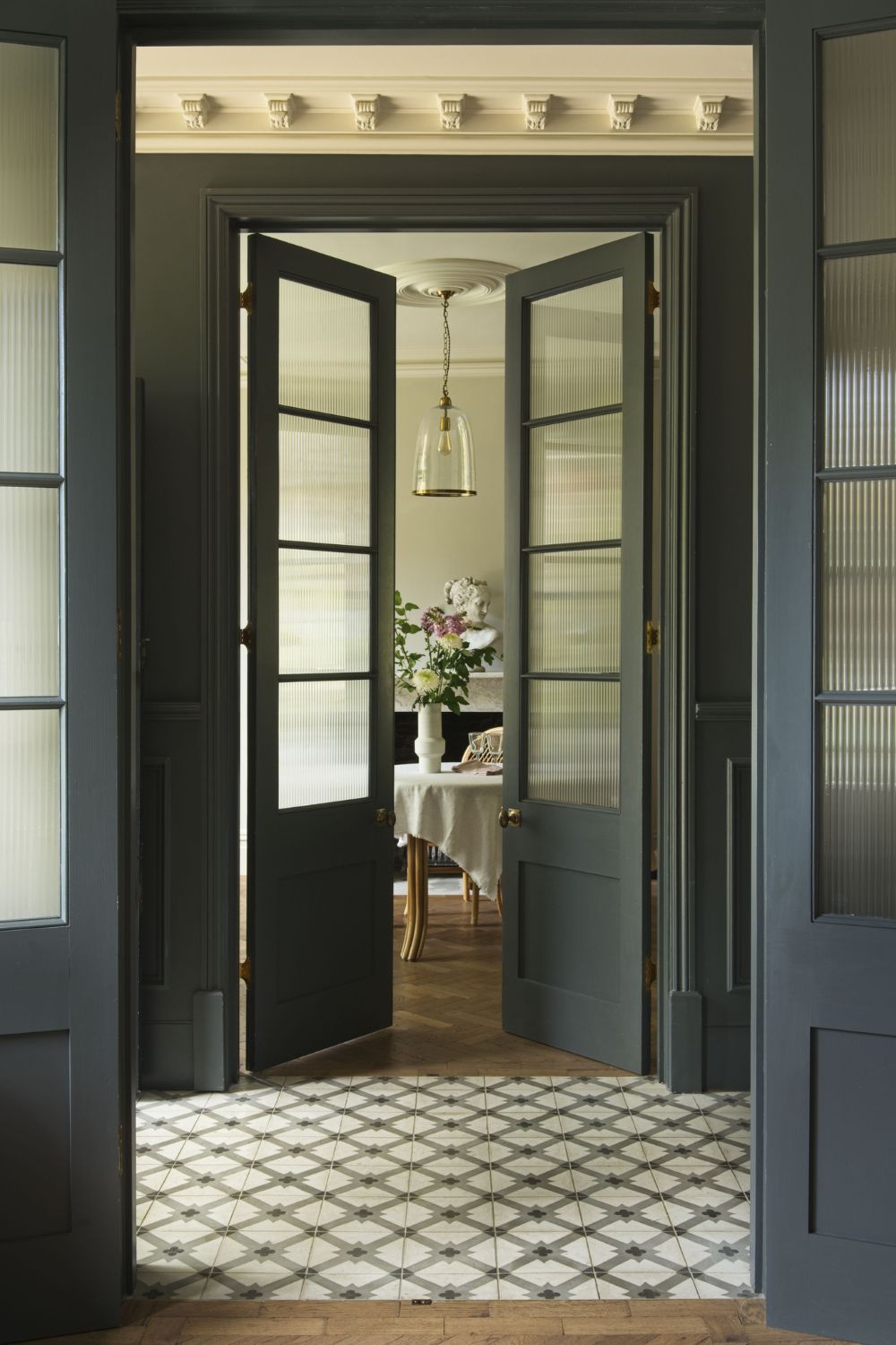 A look of elegance exudes from this tiled hallway with two doors.
