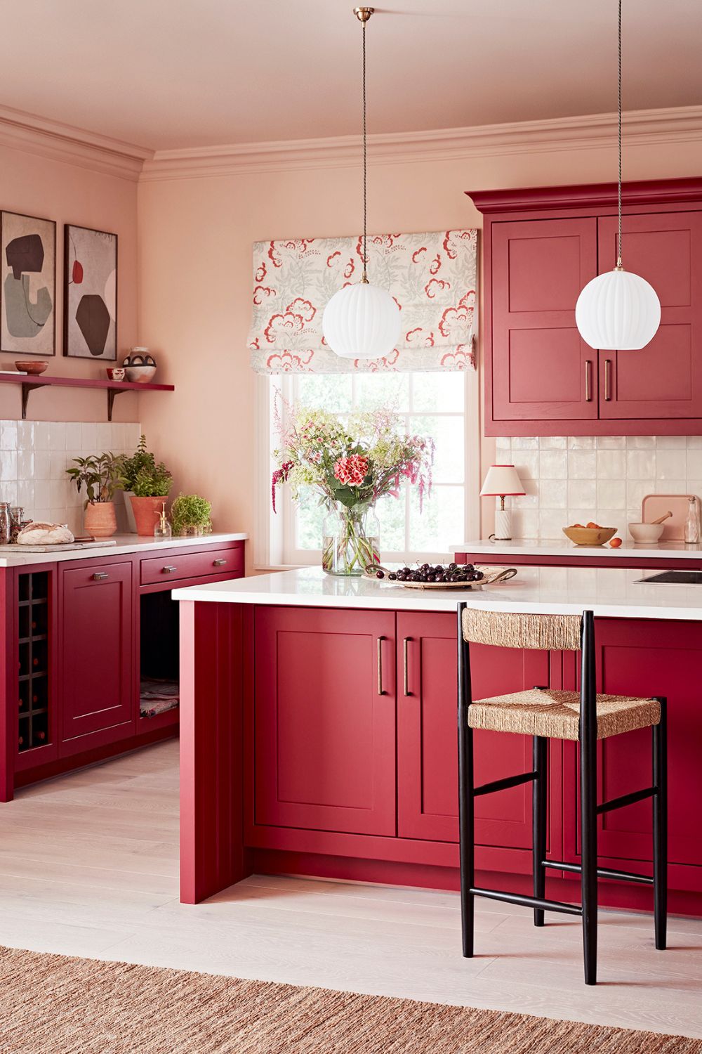 An elegant home kitchen with red cabinets and white counter tops that gives a luxurious and expensive look.