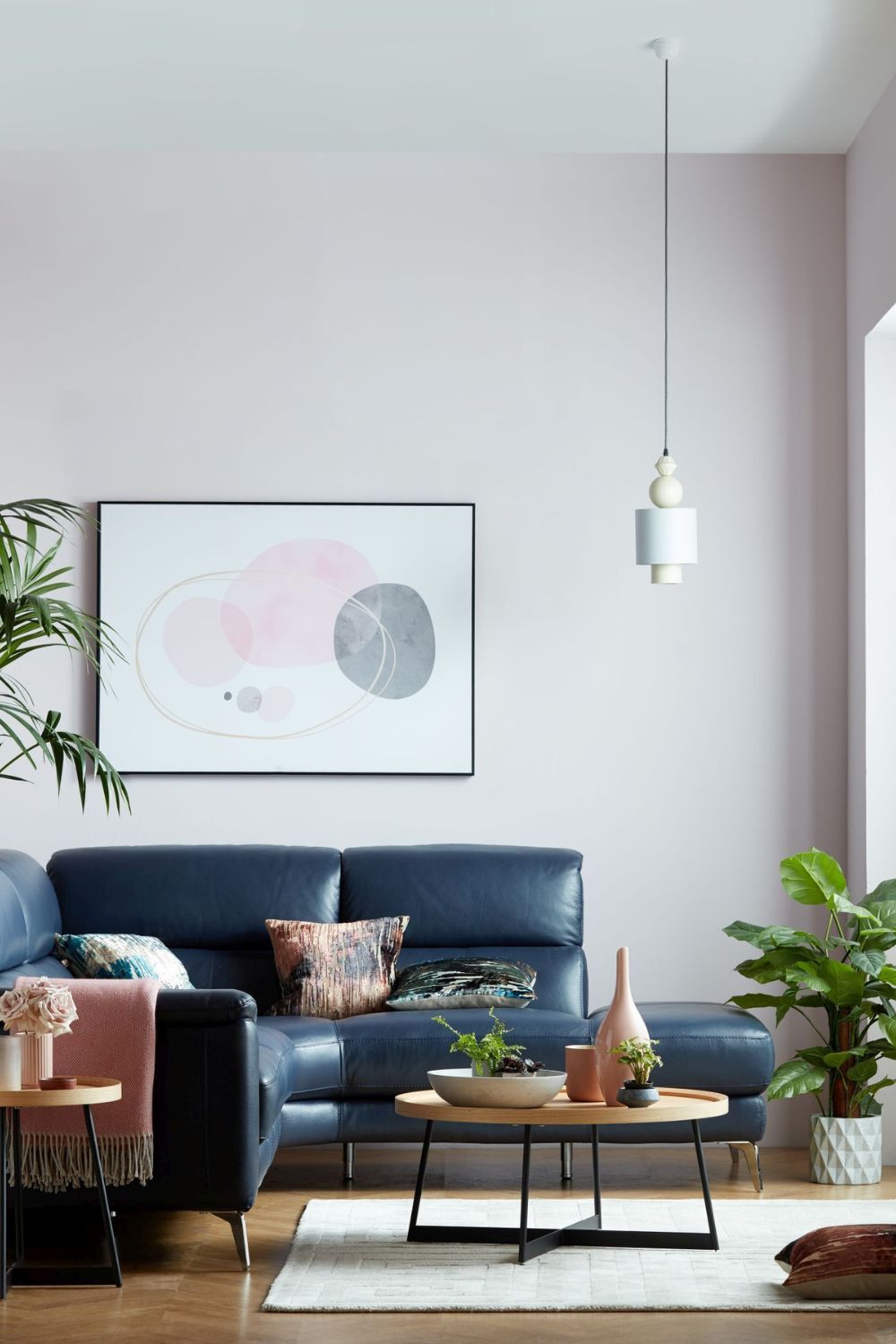 A home living room in 2024 with a blue sofa and plants, designed to have an expensive look.