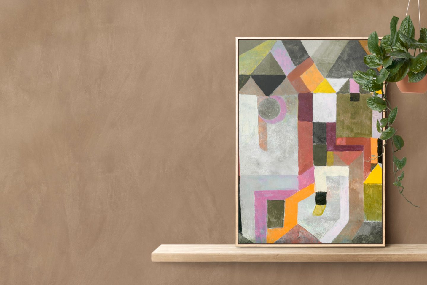 A magical worlds canvas art painting resting on a wooden shelf against a beige wall, with a green potted plant on the right.
