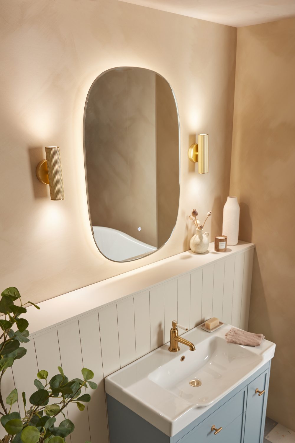 Bathroom mirror with hidden lighting above white sink