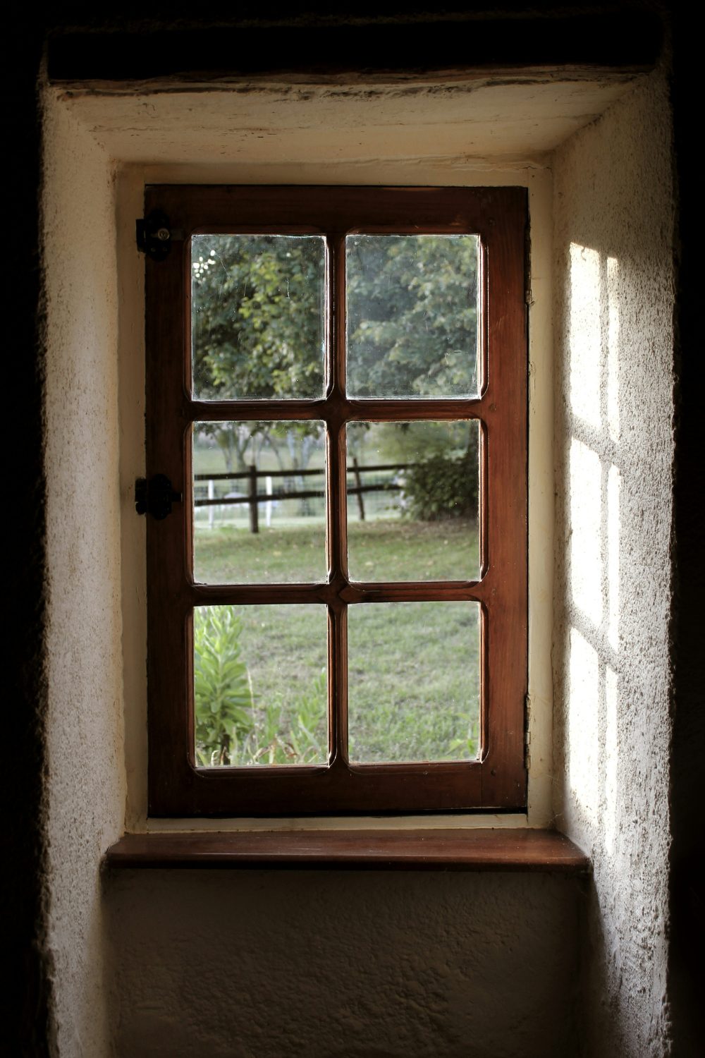 Dark room interior with wooden window and garden view