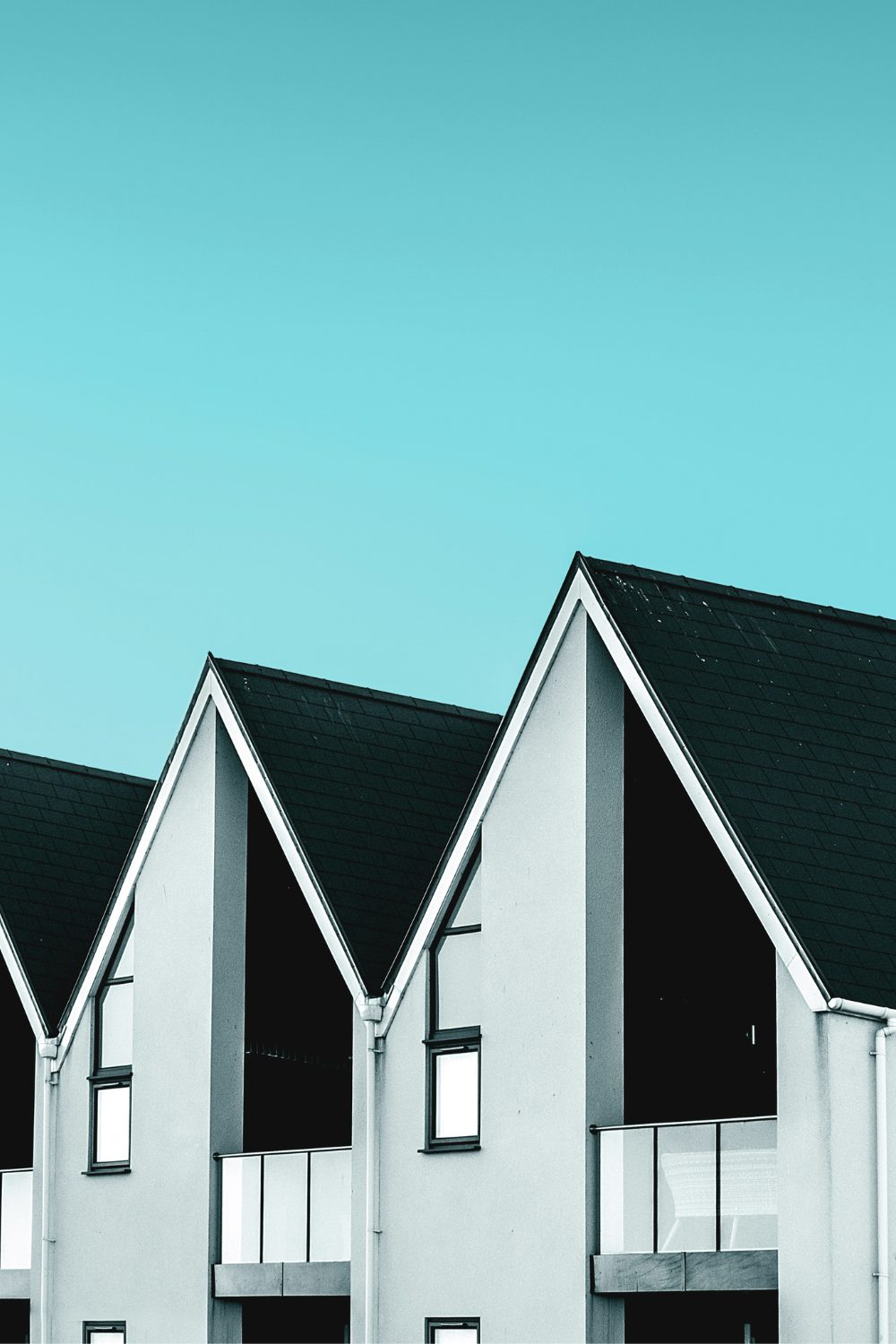 Row of modern grey houses against a bright blue sky