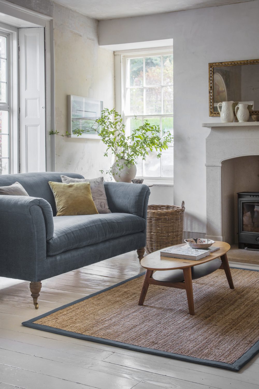 Blue sofa and jute rug in white farmhouse style living room
