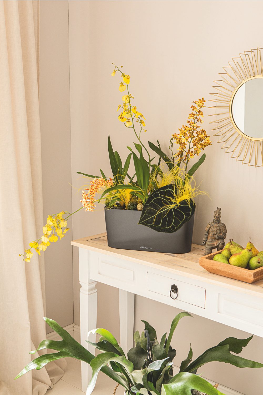 Bright yellow indoor plant on white table with mirror