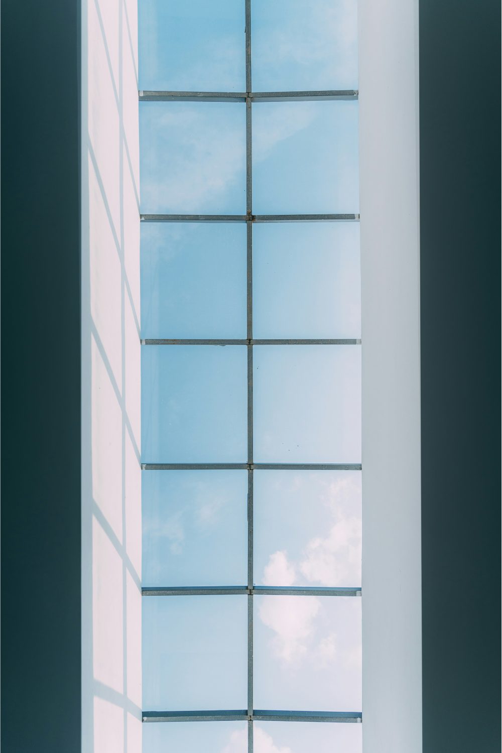 Long window with view of blue sky in dark room
