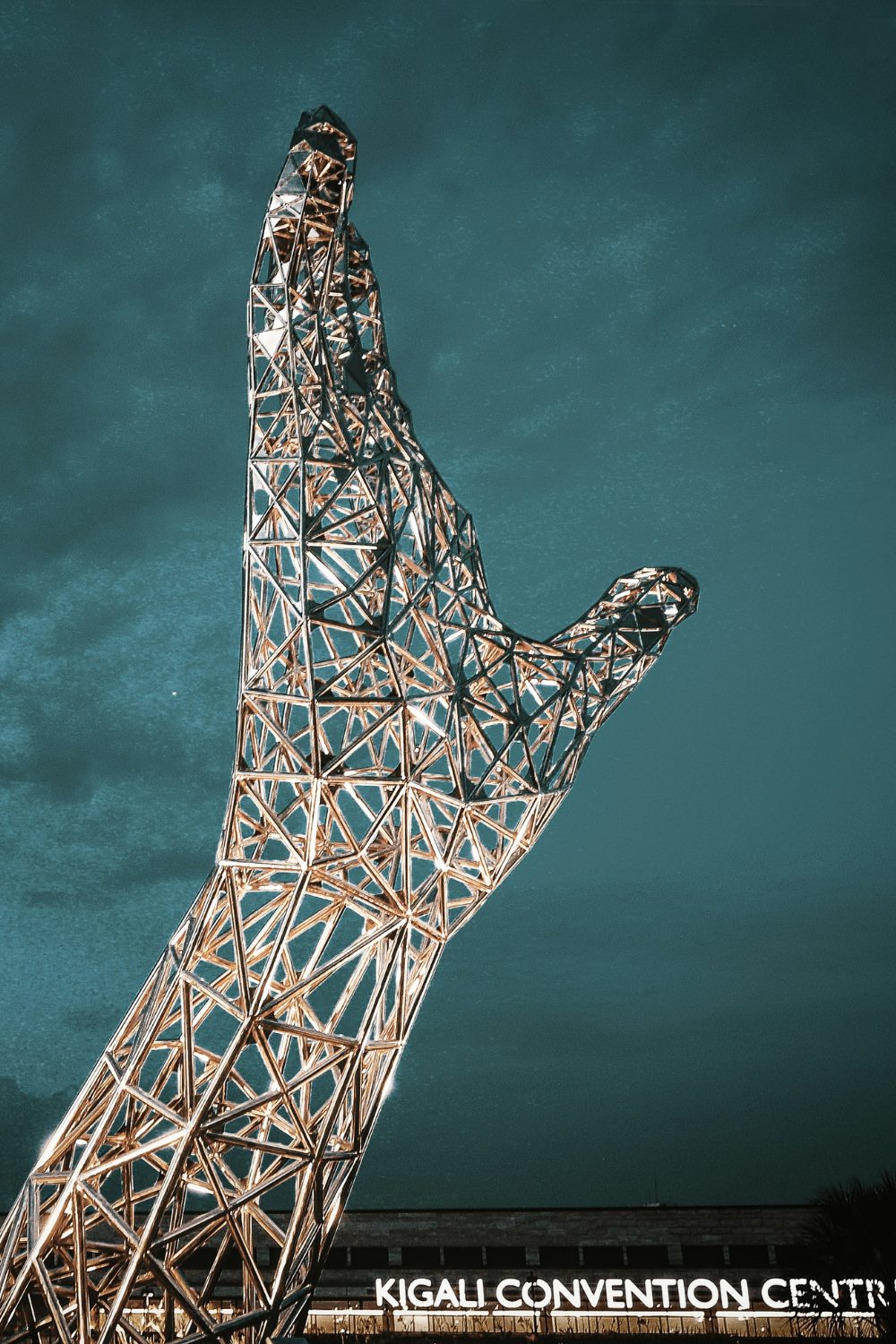 Large metal sculpture of a hand in front of the Kigali Convention Centre