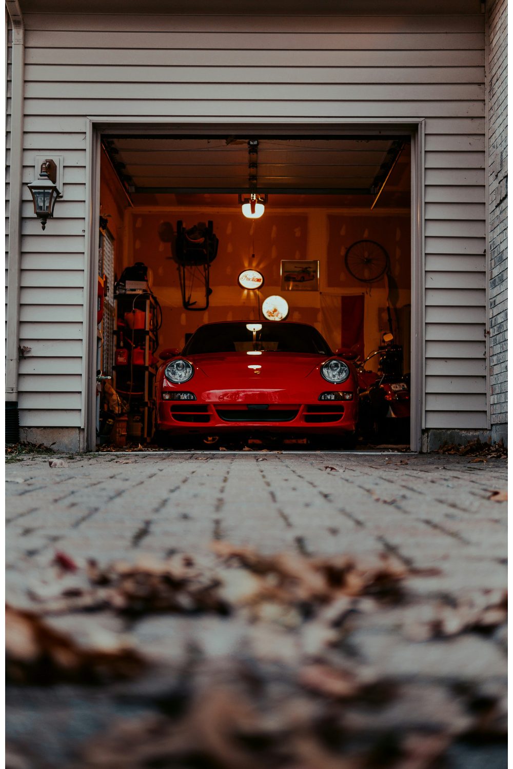 Open garage with clapboard sidings and red car inside