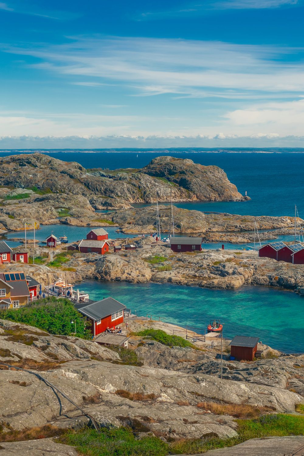 Rocky coastline with vibrant blue water and small red houses