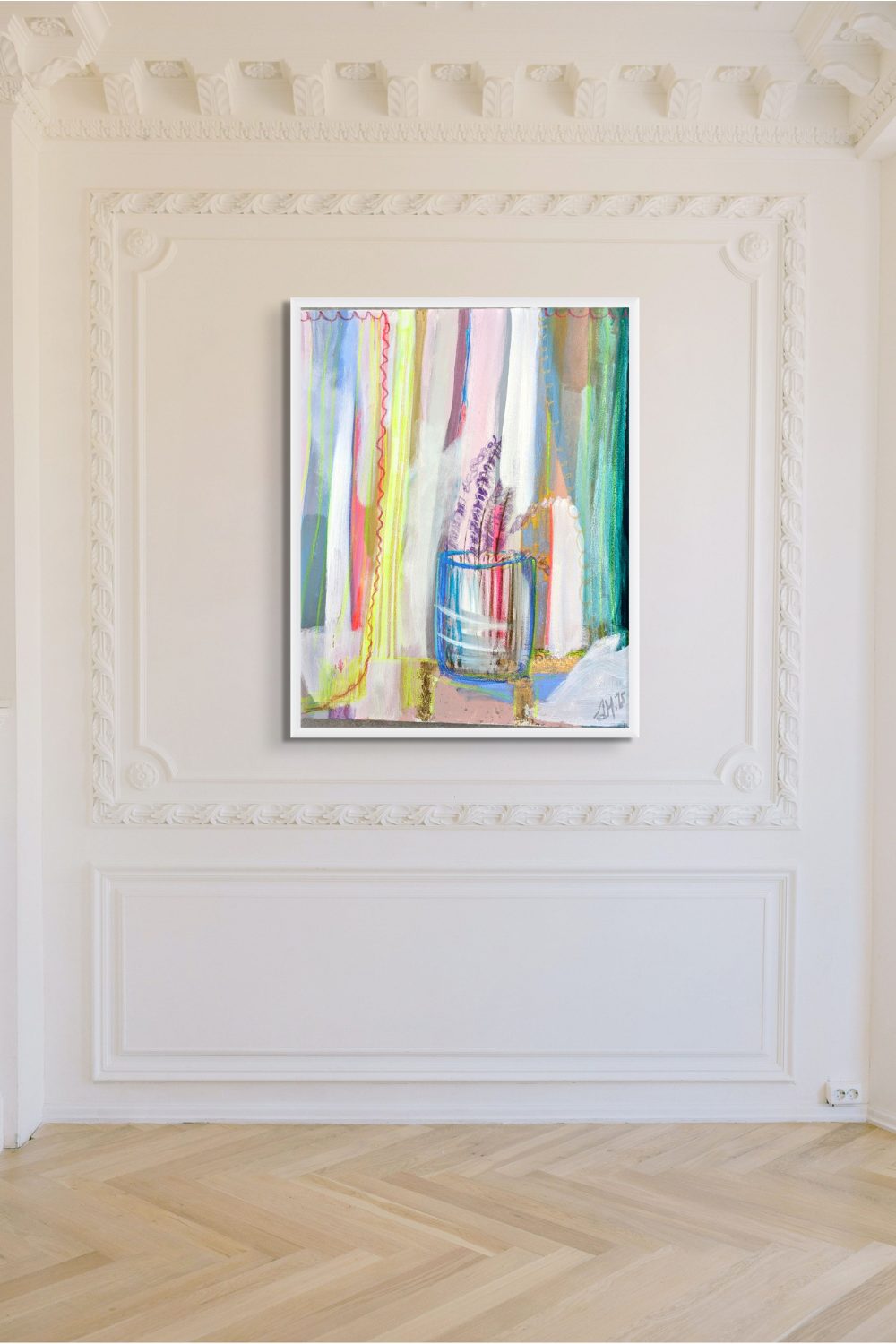 Colourful abstract print hung on white wall above wooden parquet flooring