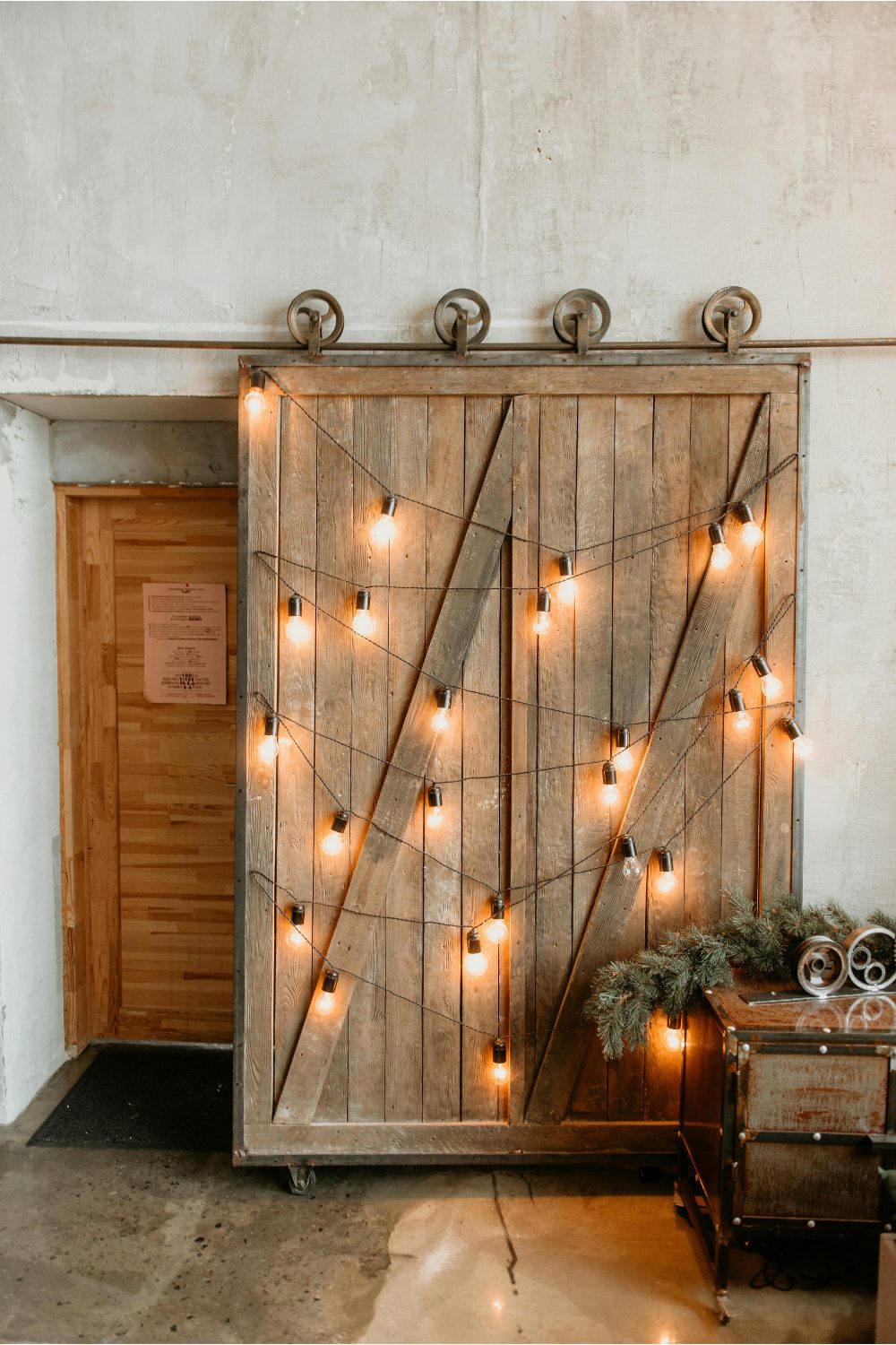 String lights across a rustic wooden roll door