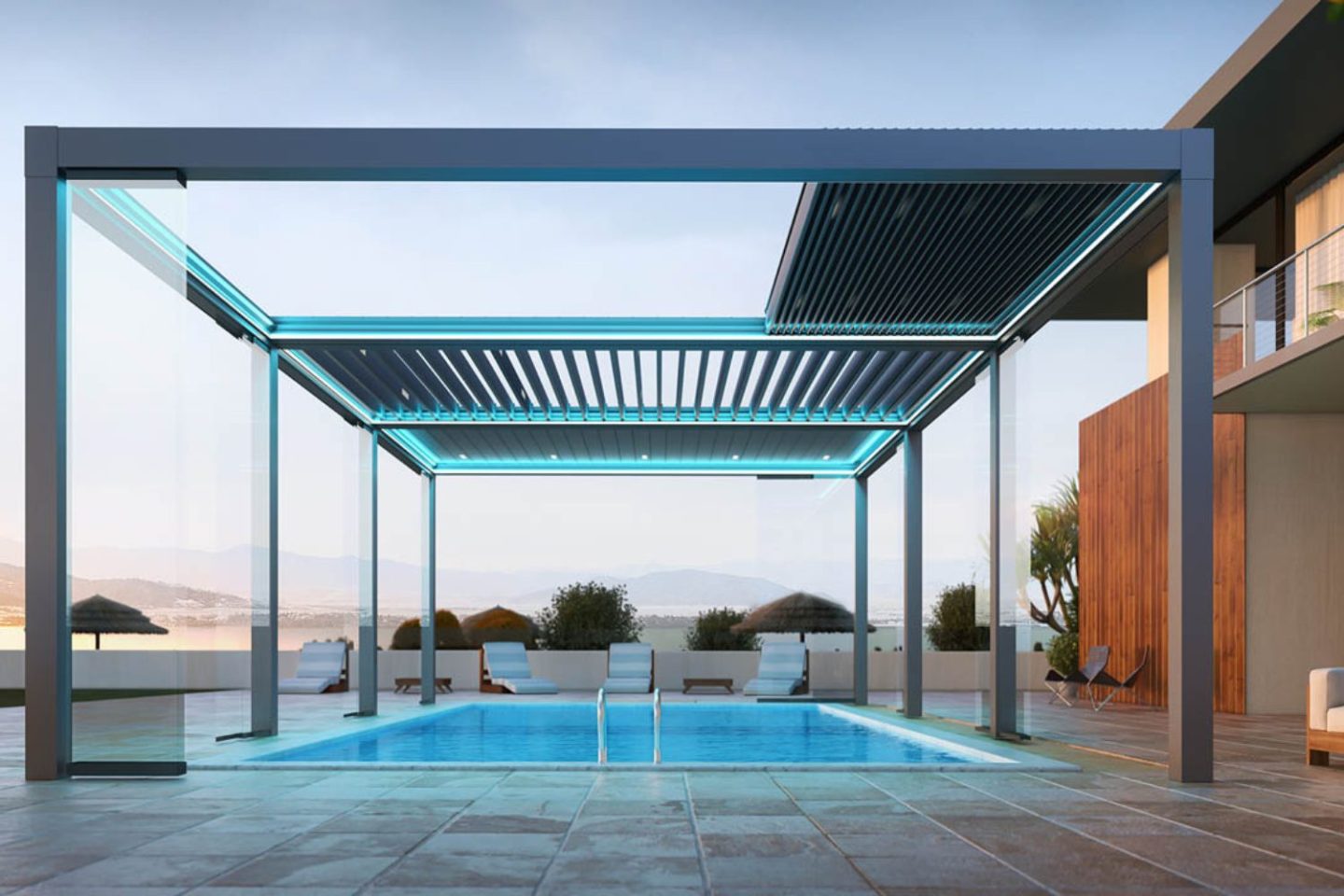 Metal pergola with retractable shades aove a pool and tiled floor next to a modern wooden house