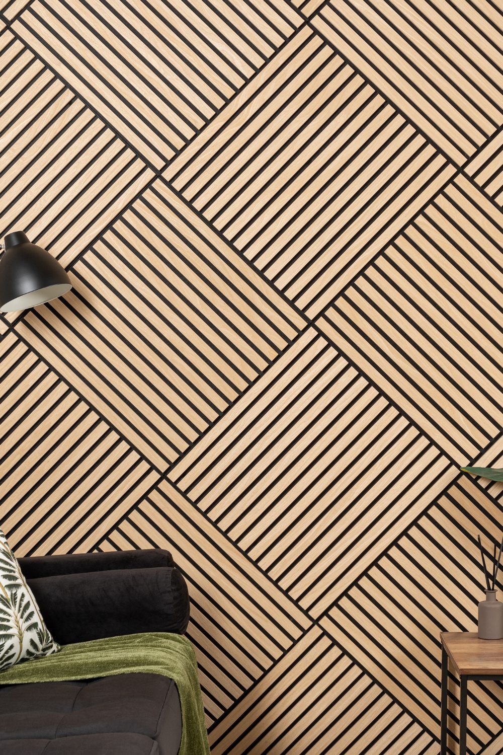 Geometric wood panelling behind black sofa and wooden table