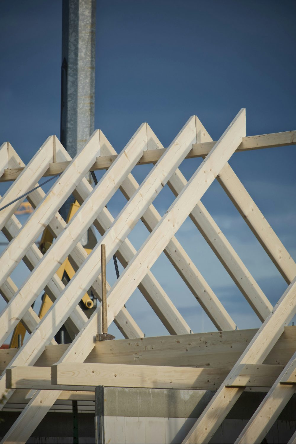 Geometric white roof beams against a blue sky