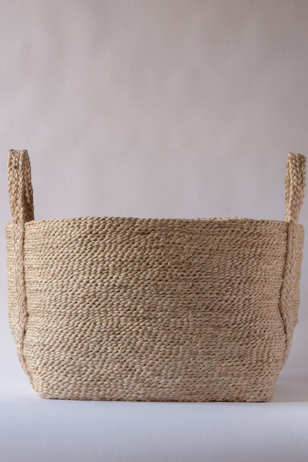 Woven jute basket on white shelf