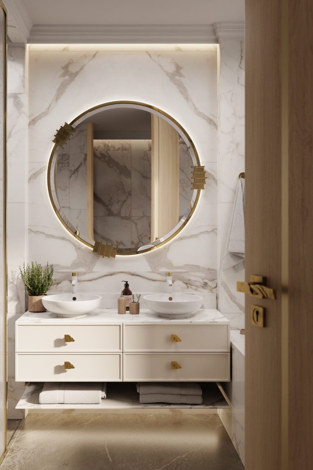 White cabinet and sinks below large round gold mirror in white bathroom