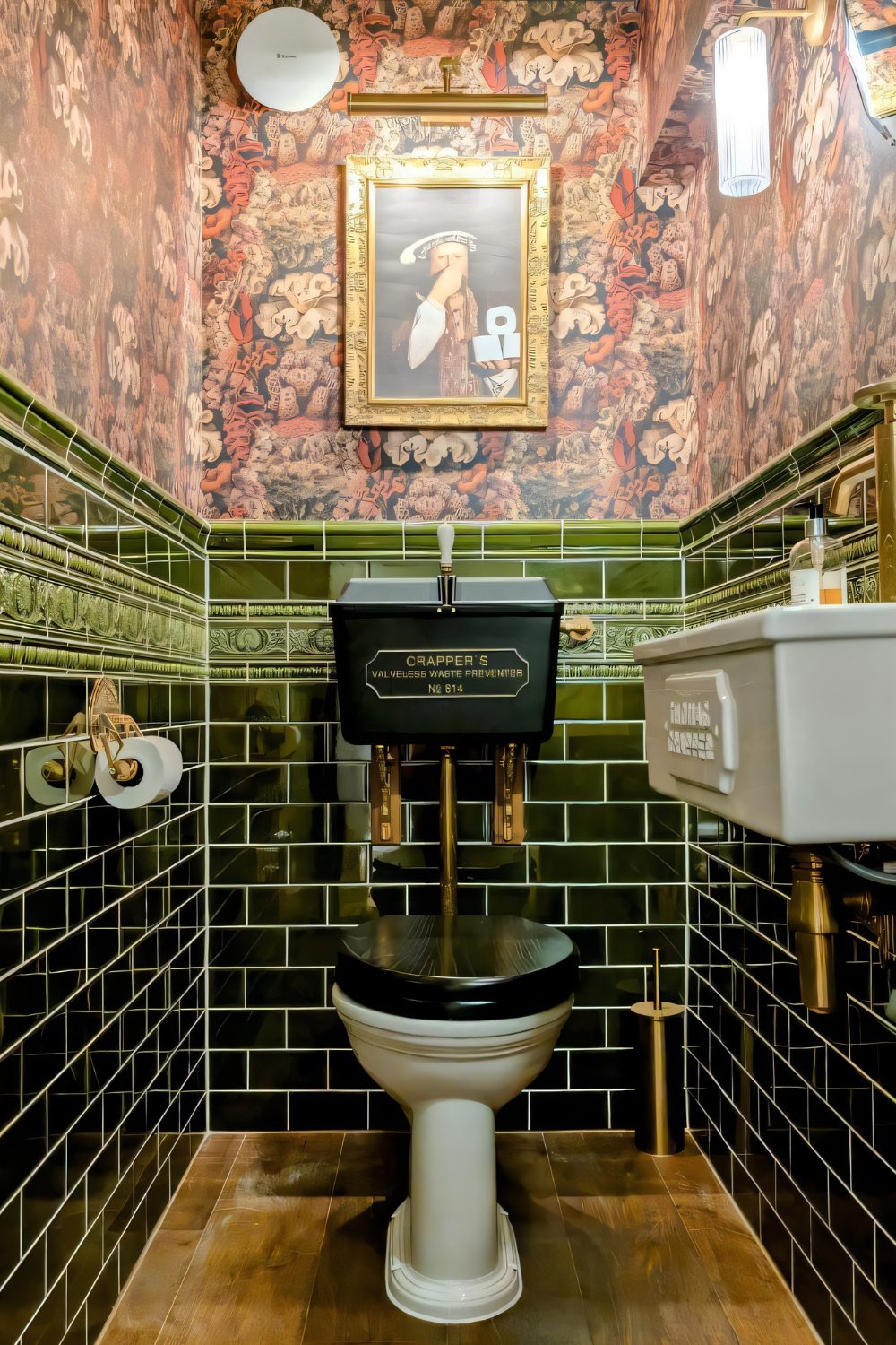 Wood-floored bathroom with dark green tile and red floral wallpaper