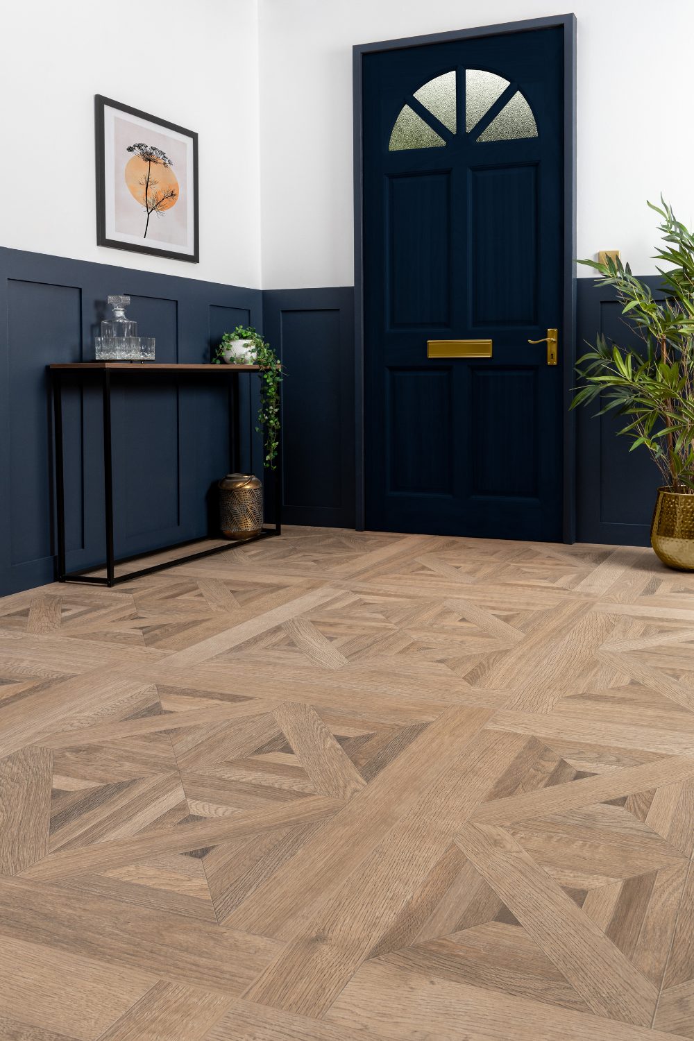 White and navy hallway with wooden table, gold plant pot and wooden tile floor