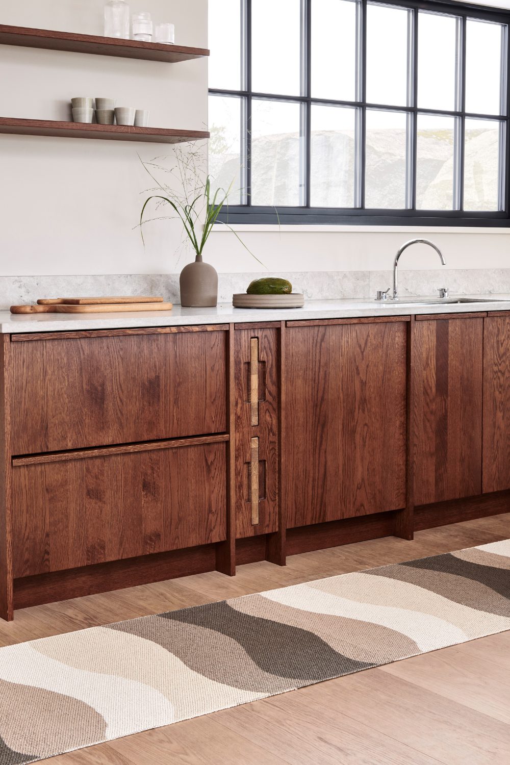 Kitchen with wooden cabinets, white marble counter and brown rug