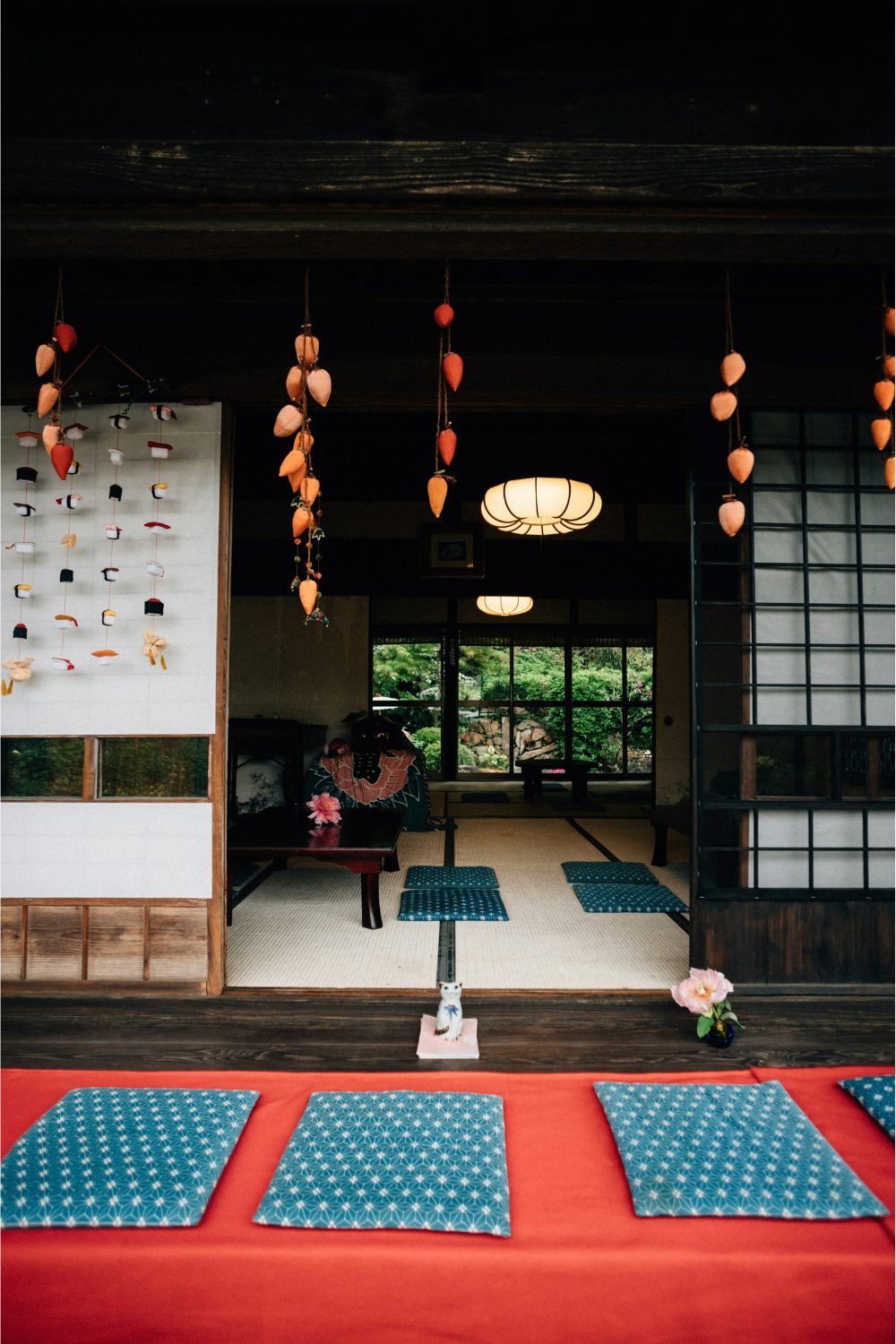 Traditional Japanese house with paper walls, floor mats and vines of hanging orange flowers