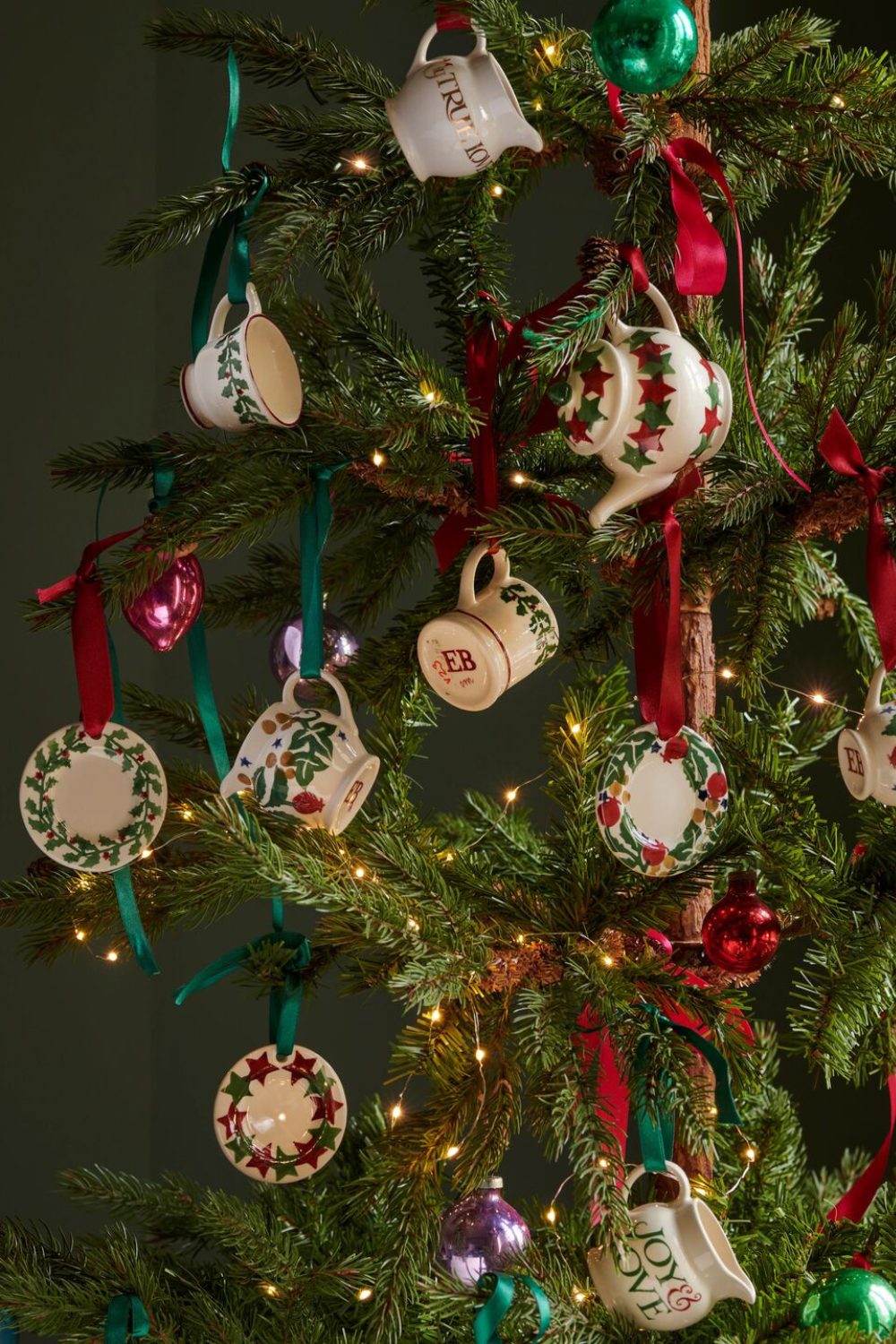 Christmas tree with tea set decorations, lights, and red ribbon