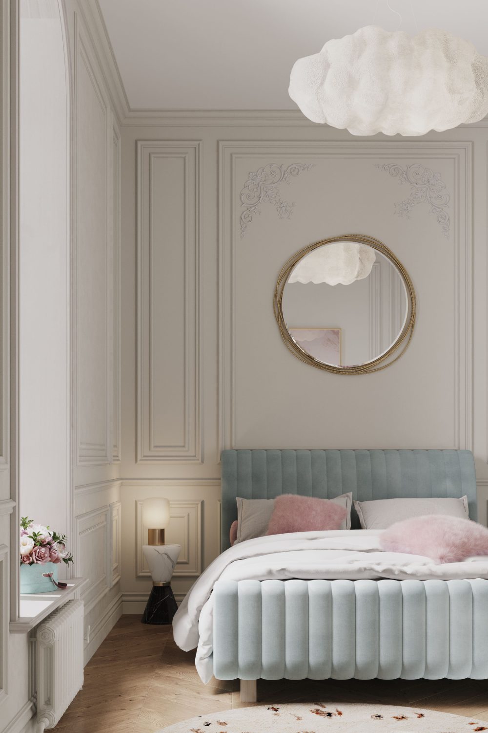 Light blue bed with pink cushions in bedroom with white wooden panelling, round mirror and cloud lampshade