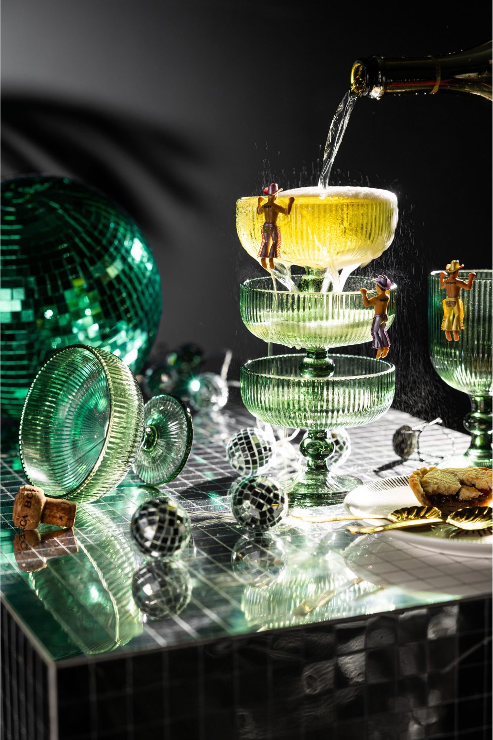 Shiny silver table holding stack of champagne glasses and disco balls