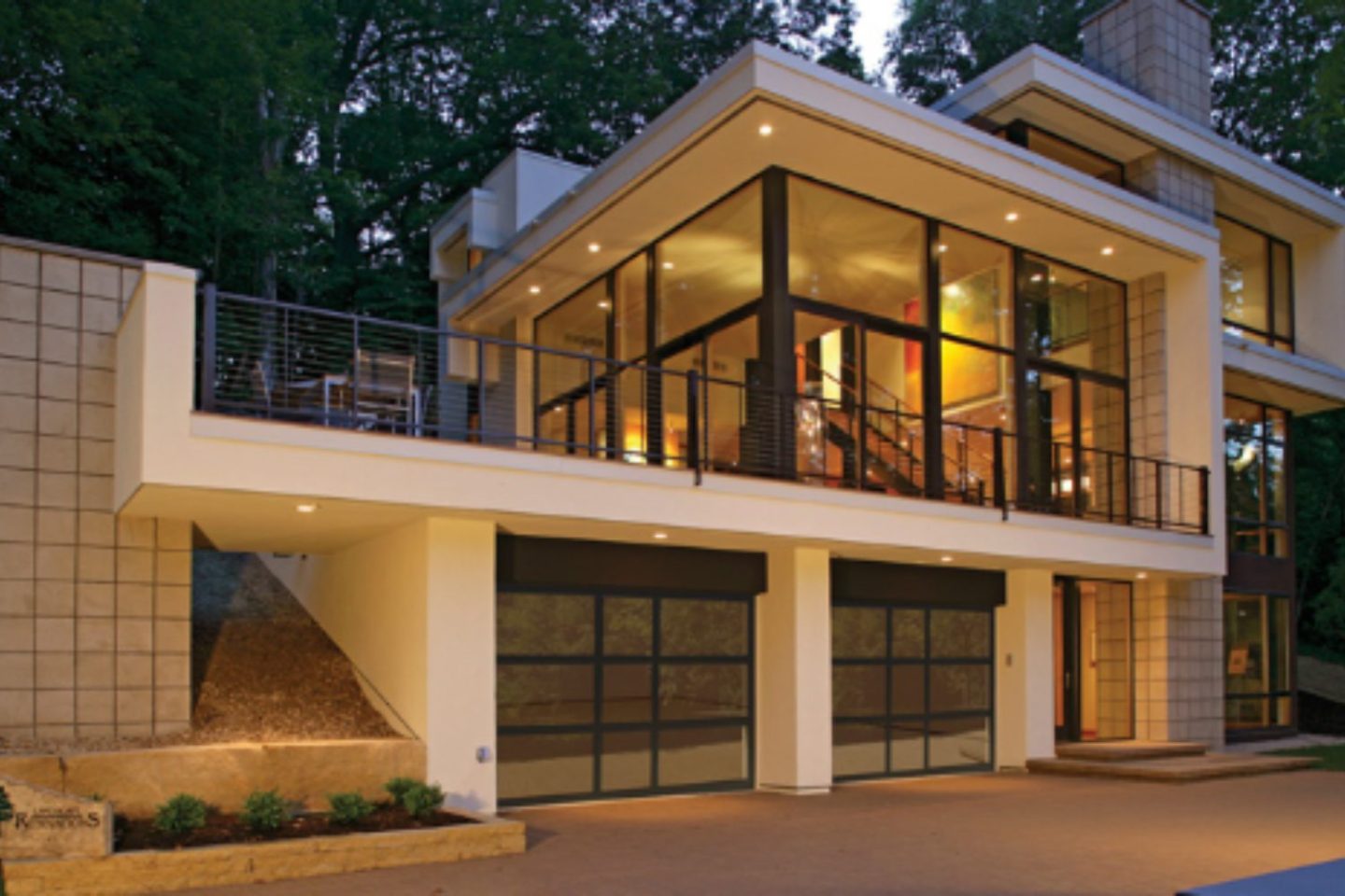 Modern glass and metal building with ground-level glass-fronted garages