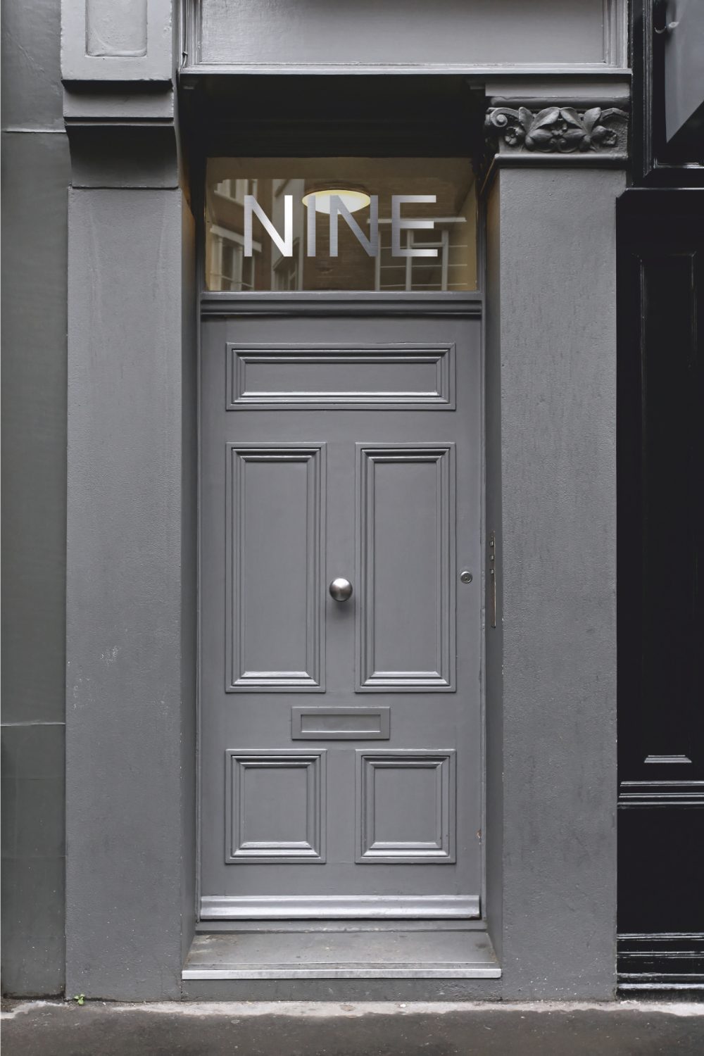 Grey front door flanked by grey pillars