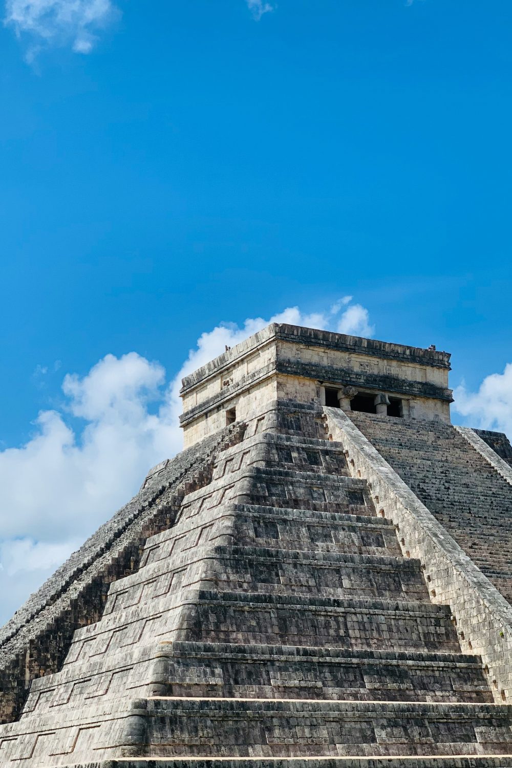 Chichen Itza: stone stepped pyramid against blue sky