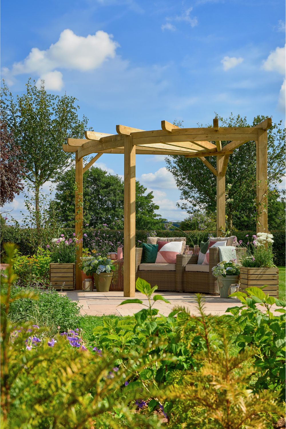 Wooden pergola in garden over wicker chairs and red cushions