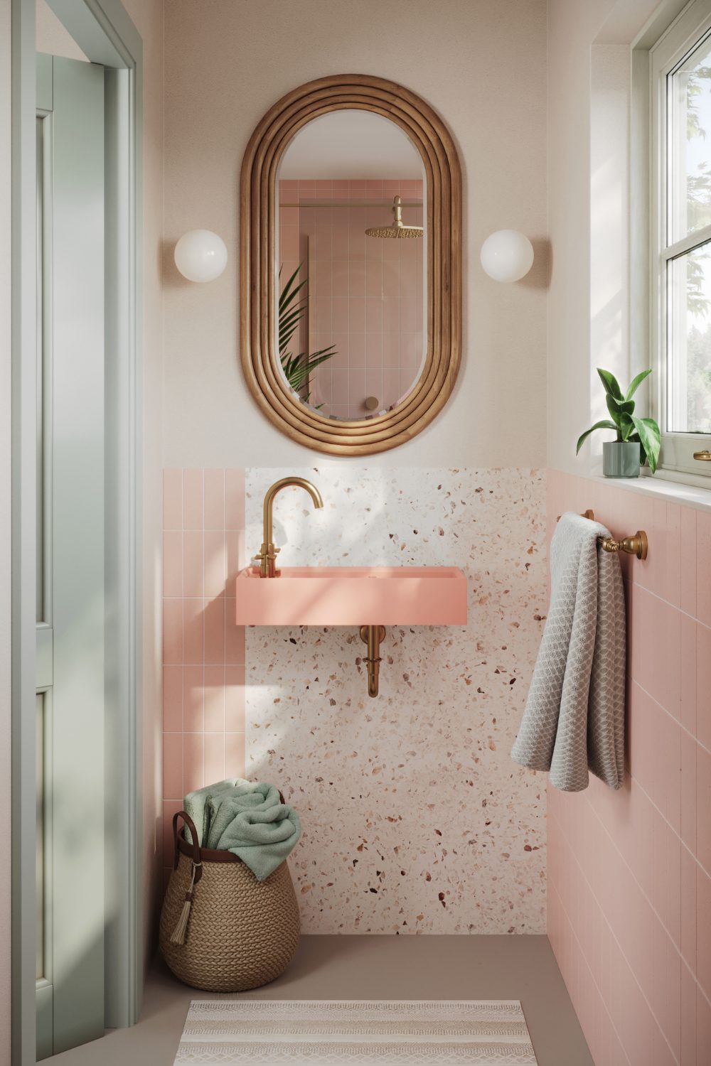 Bathroom with curved bamboo mirror, pink sink, pink tiles, white rug and potted plant