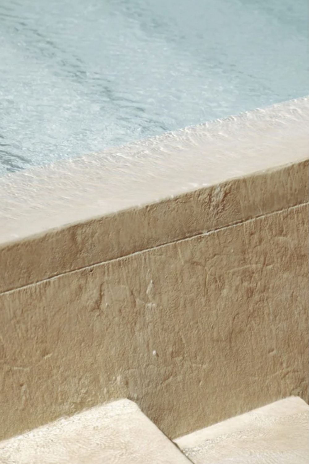 Pale stone edge of pool and stairs