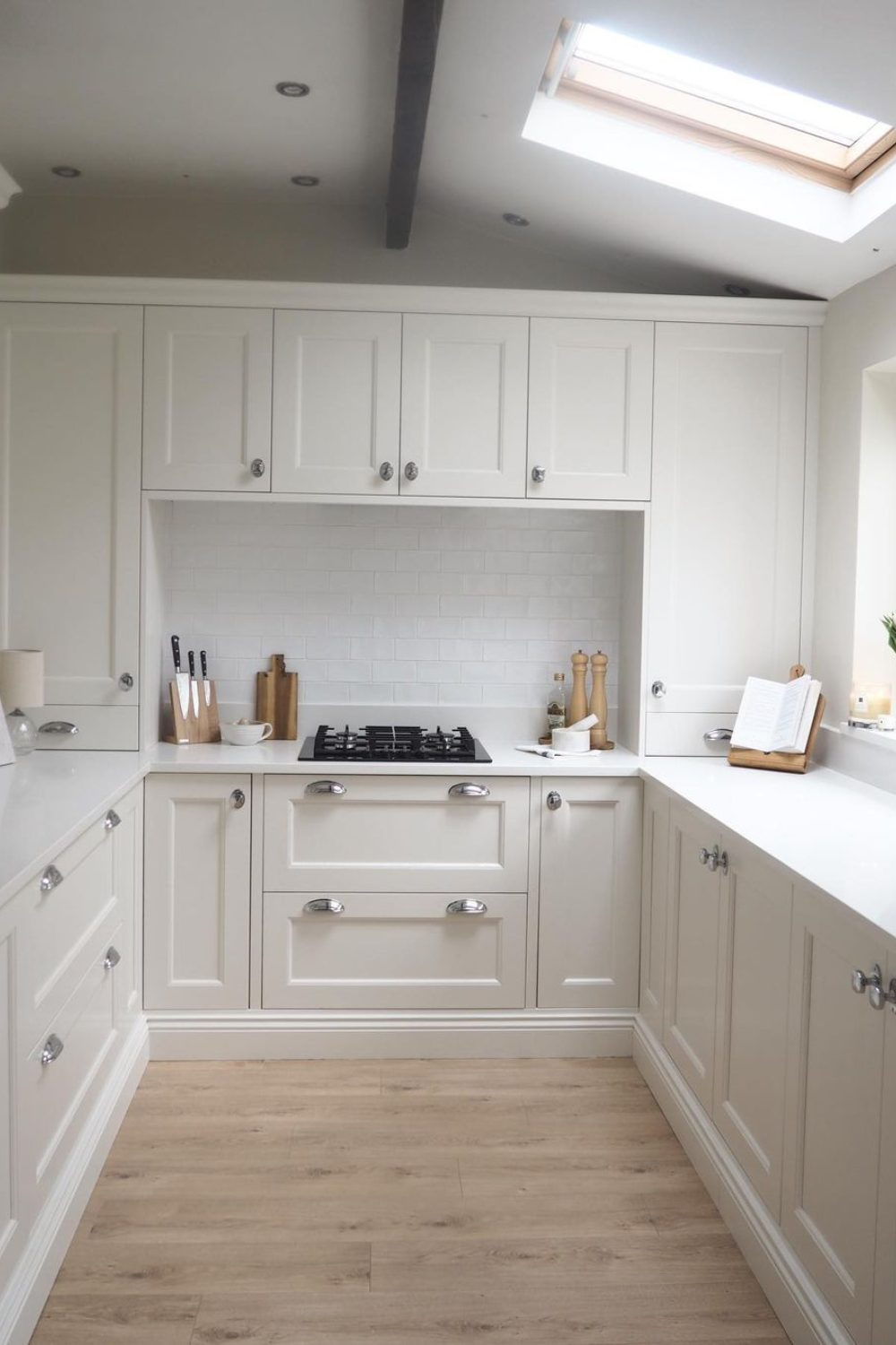 White kitchen with wooden floor and skylight