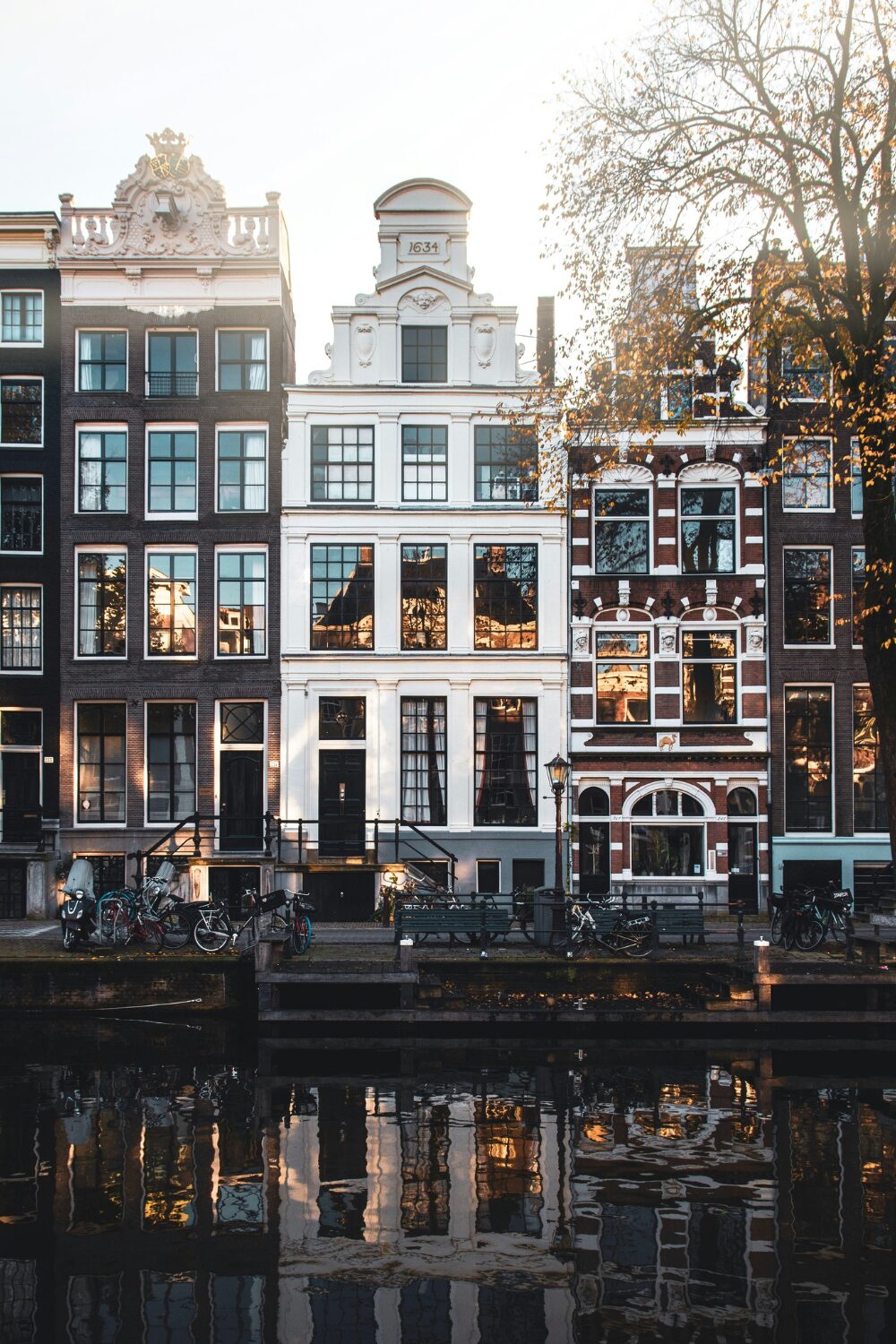 Row of historic white and red brick Amsterdam houses on canal