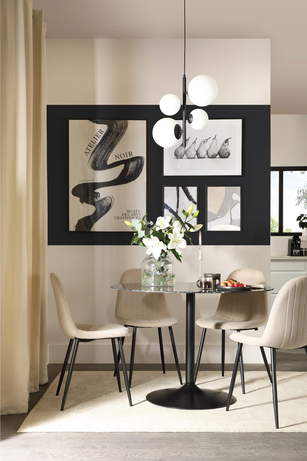 White dining room with glass table, white chairs and black & white gallery wall