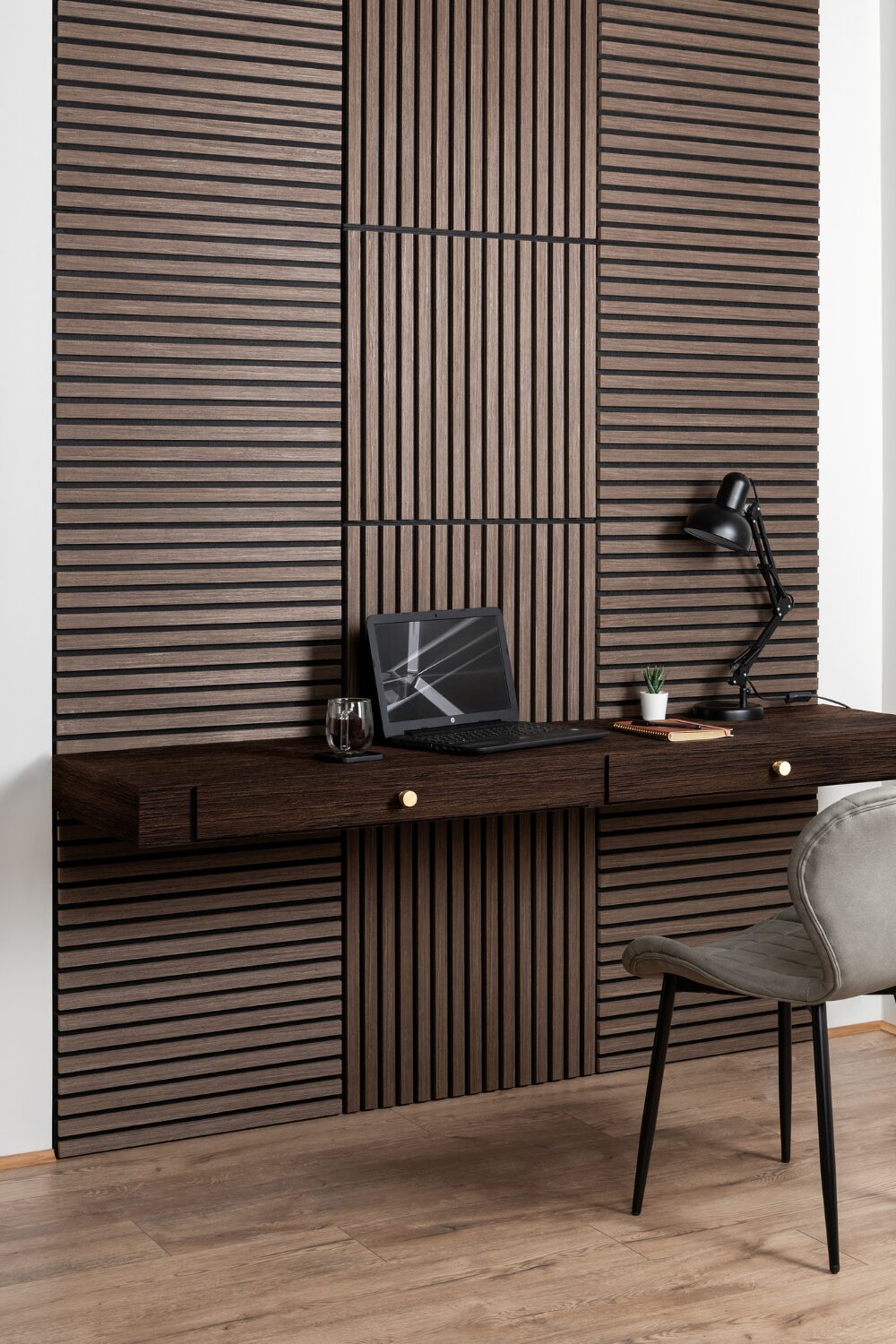 Wooden slat feature wall behind dark wood desk and grey chair