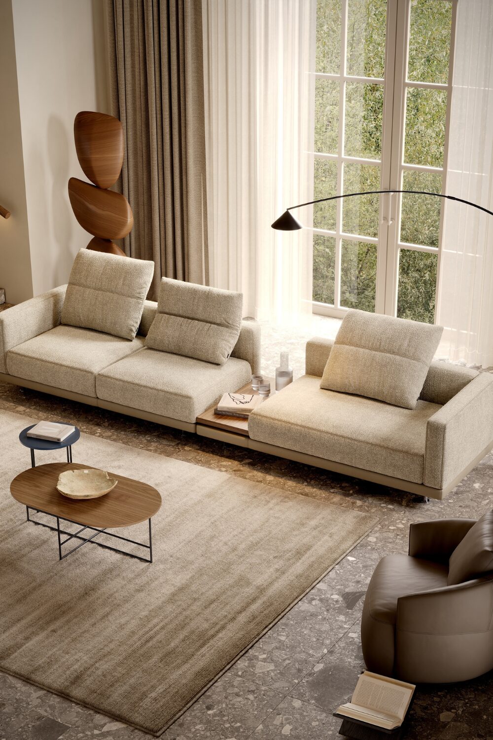 Beige living room with long sofa, wooden sculpture, brown armchair and large rug