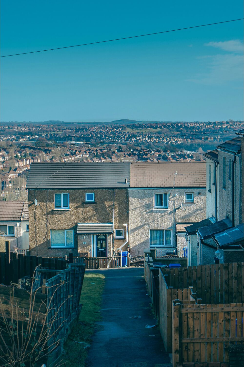 Terraced houses in front of view of valley with houses and hills