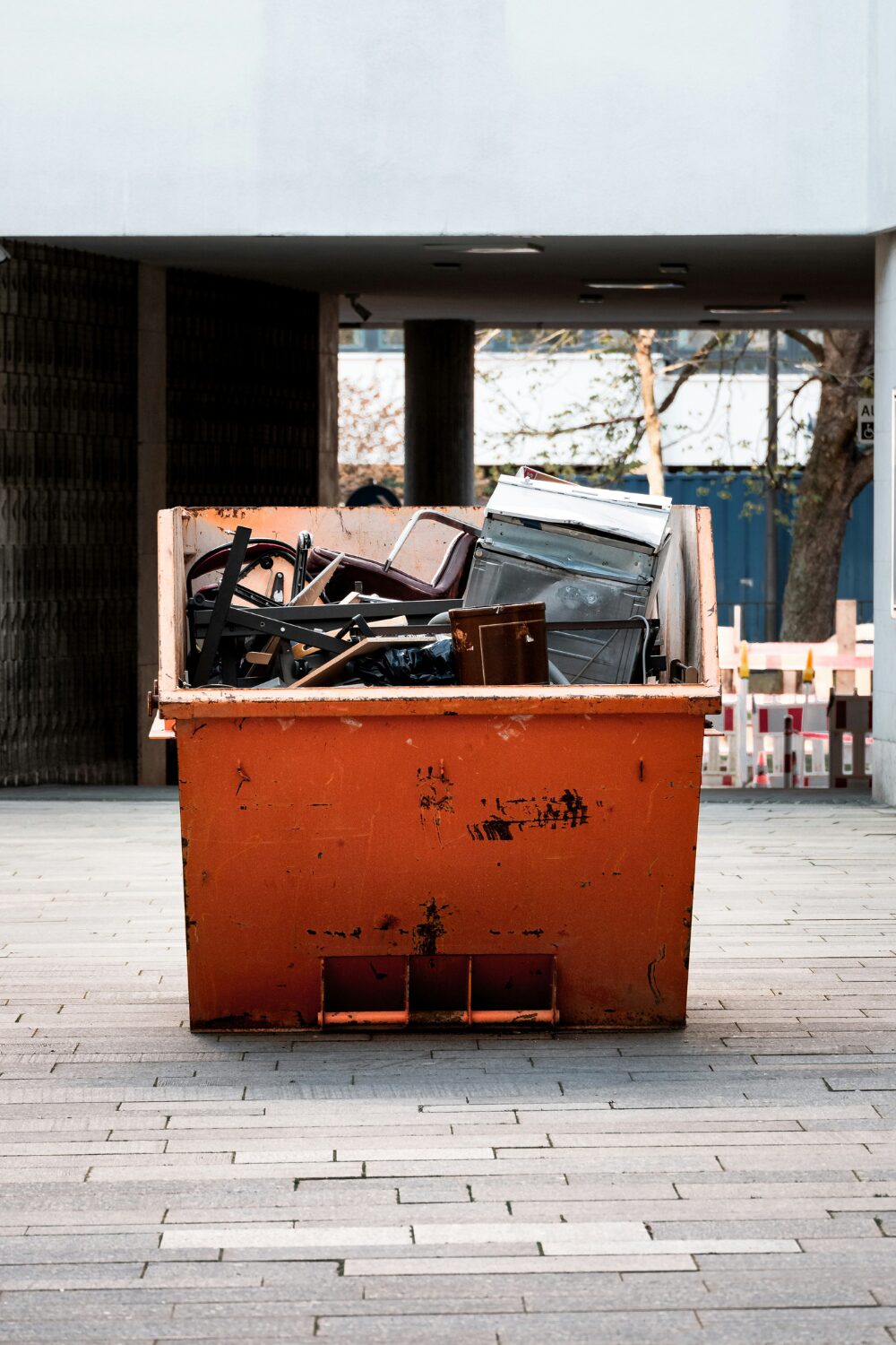 Yellow skip on outside grey tiled flooring