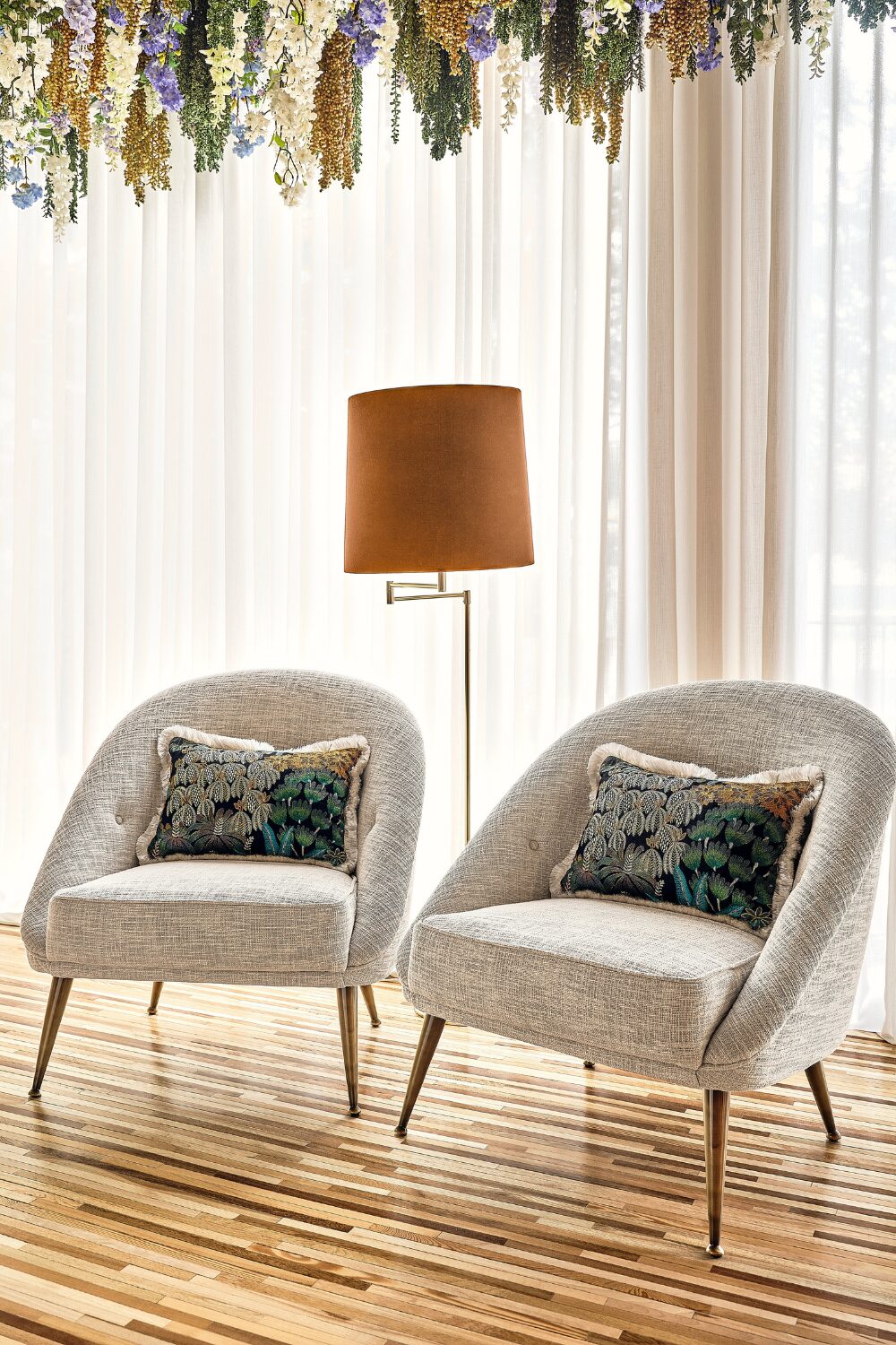 Two grey chairs and standing lamp on wooden floor