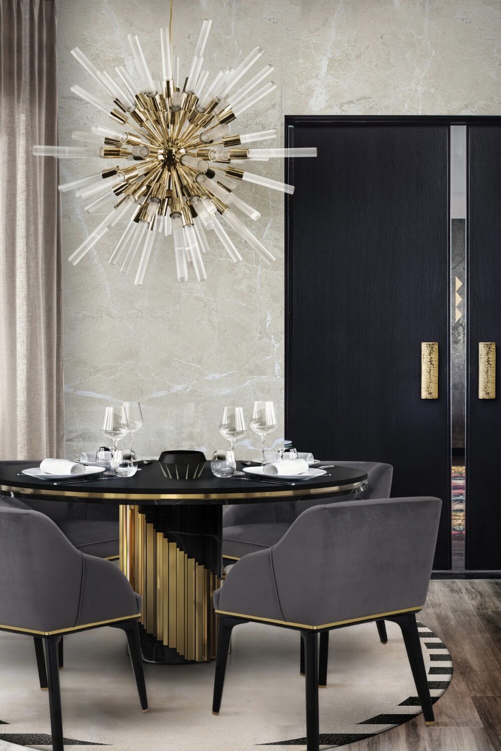 Black & gold dining table with grey chairs under a starburst lighting fixture